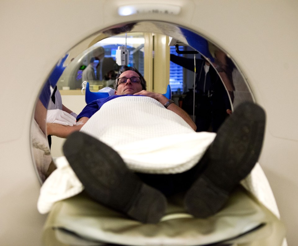 a man is laying in a ct scan machine