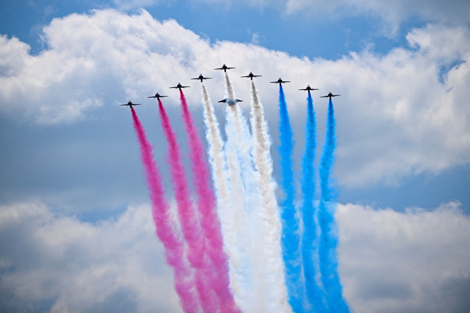 PORTSMOUTH, ENGLAND - JUNE 5: Aircrafts release smoke in red, white and blue colours during a flypast during the UK's national commemorative event for the 80th anniversary of D-Day in Southsea Commons on June 5, 2024 in Portsmouth, England. King Charles III and Queen Camilla lead the commemorative events in Portsmouth ahead of the actual 80th Anniversary of D-Day on June 6th. Veterans, VIP Guests and school children are attending an event on Southsea Common. Portsmouth was where tens of thousands of troops set off to Normandy to participate in Operation Overlord. They established a foothold on the French coast and advanced to liberate northwest Europe. (Photo by Dylan Martinez - Pool/Getty Images)