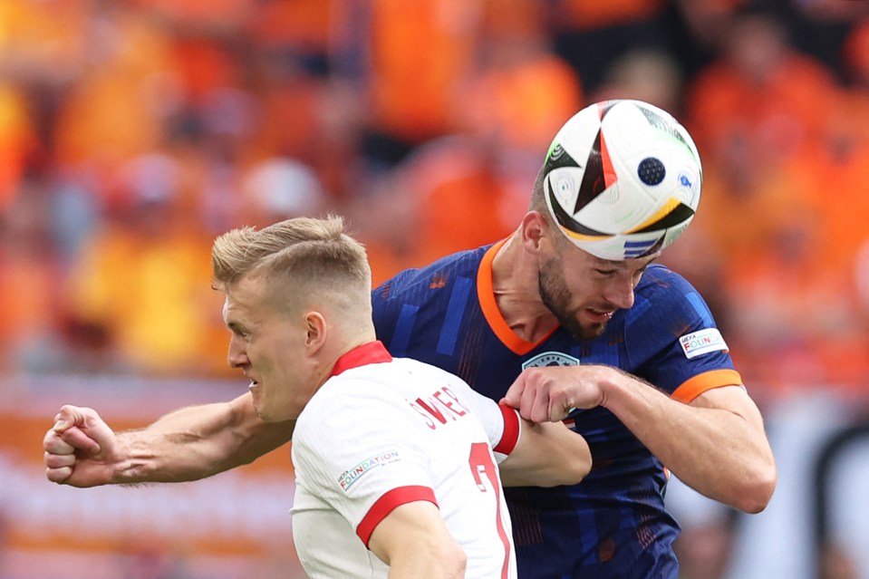 Karol Swiderski fights for the ball with Netherlands' defender Stefan de Vrij