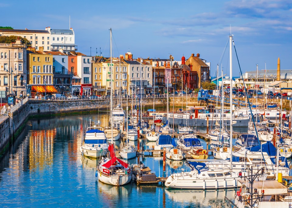 boats are docked in a harbor with buildings in the background