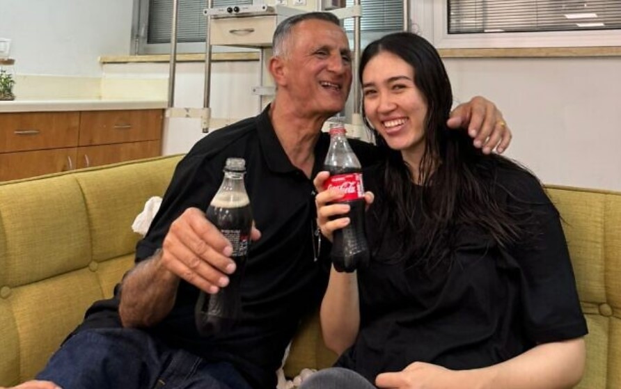 Noa enjoying a chilled bottle of Coke with her father as she is brought back home safely