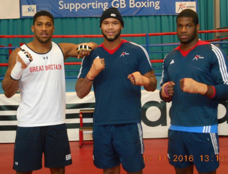 three boxers stand in front of a banner that says supporting gb boxing