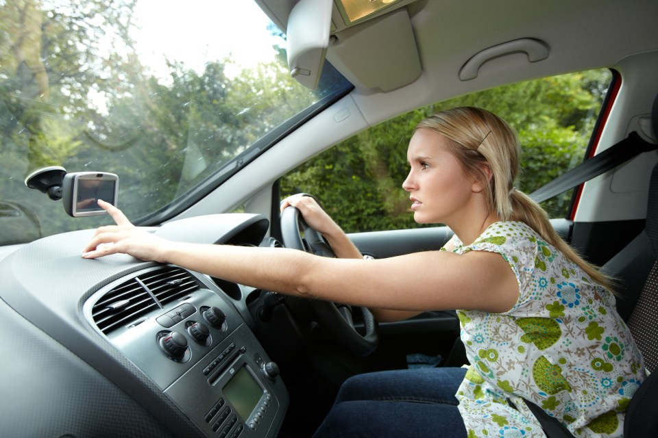 a woman is sitting in a car looking at her phone