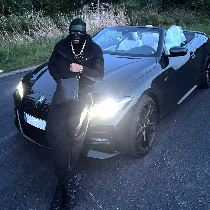 The musician, from Gothenburg, poses in front of a BMW in his trademark black mask