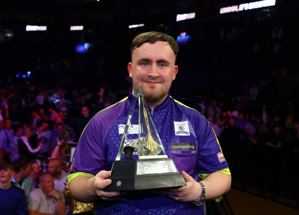 Darts - 2024 Premier League - Play-Offs - London - The O2, London, Britain - May 23, 2024 Luke Littler celebrates with a trophy after winning his final match against Luke Humphries Action Images via REUTERS/Matthew Childs