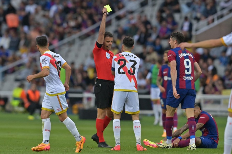 Spanish referee Jesus Gil Manzano givs a yellow card to Rayo Vallecano's Spanish midfielder #23 Oscar Valentin during the Spanish League football match between FC Barcelona and Rayo Vallecano de Madrid at the Estadi Olimpic Lluis Companys in Barcelona on May 19, 2024. (Photo by MANAURE QUINTERO / AFP) (Photo by MANAURE QUINTERO/AFP via Getty Images)