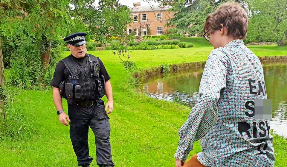 a man wearing a shirt that says " ea s rise " talks to a police officer