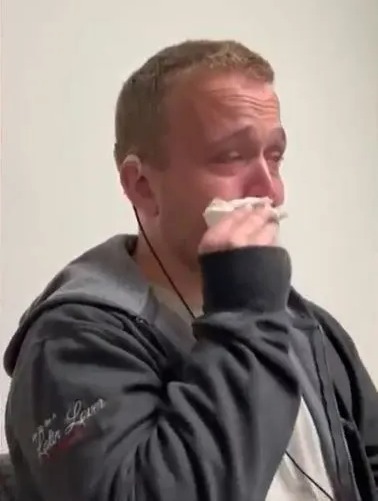 Aric wipes his nose in an emotional video