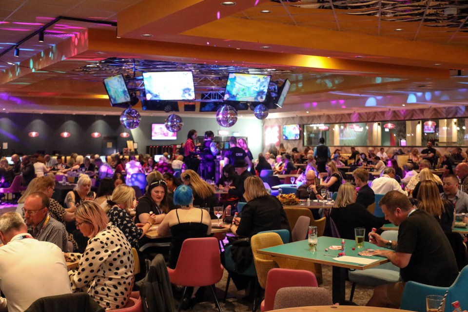 a group of people are sitting at tables in a restaurant