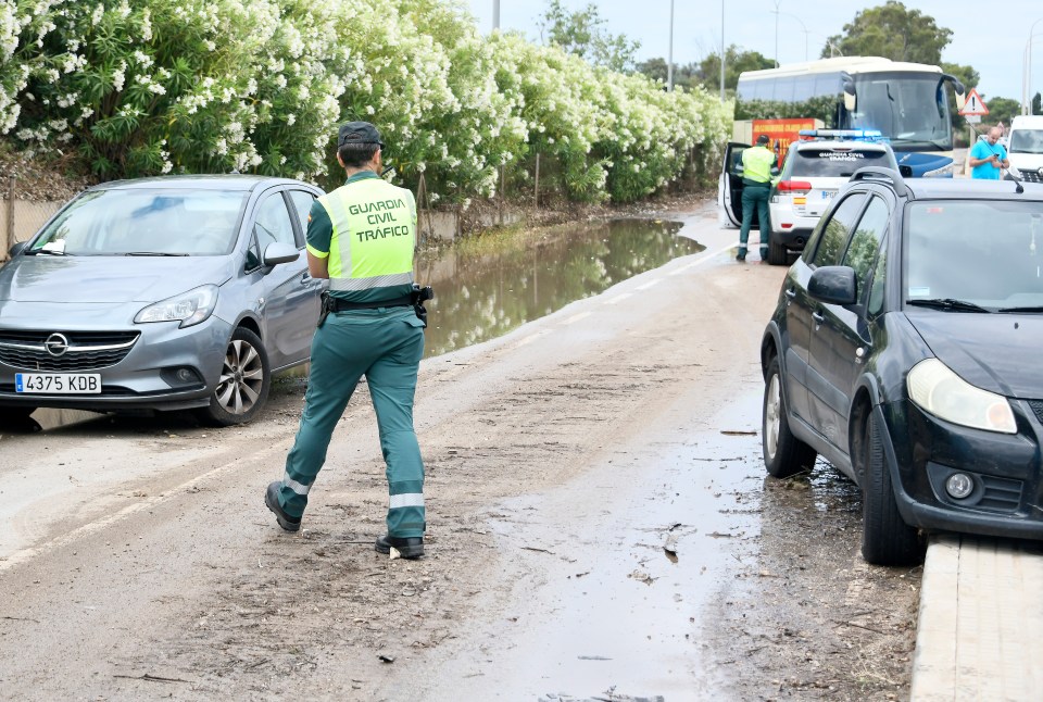 Cars navigating the debris left behind by the floods