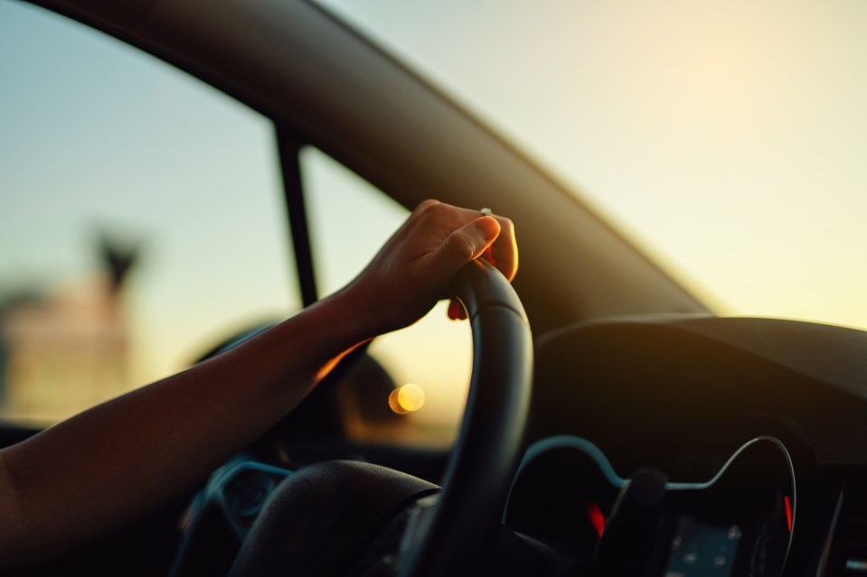 a person 's hand is on the steering wheel of a car