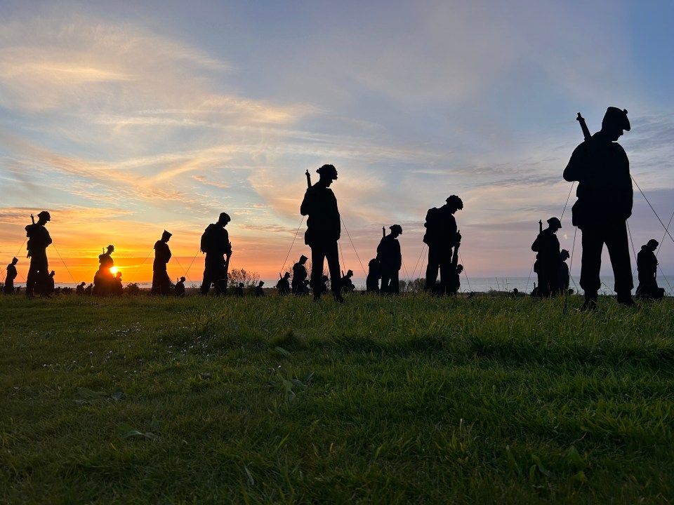 The brave souls are represented by a silhouette, stood head bowed, in the long grass overlooking Gold Beach