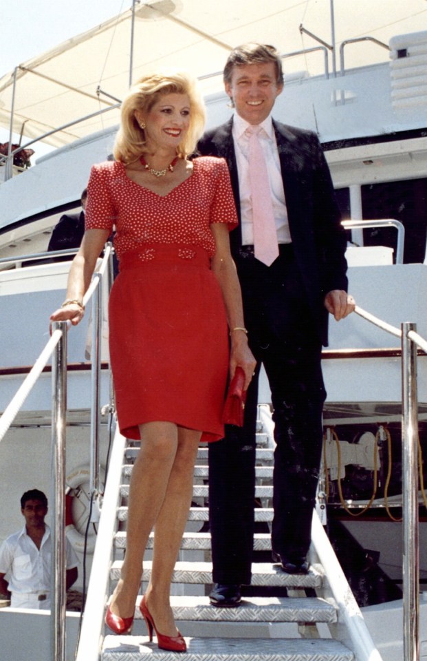 a woman in a red dress is standing next to a man in a suit