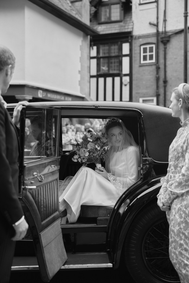 The stunning bride emerges from the car to attend the ceremony