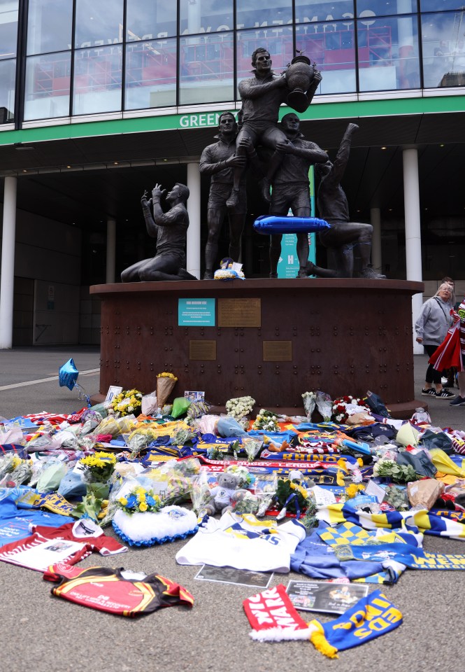 a bunch of shirts and scarves are laid out in front of a building that says green