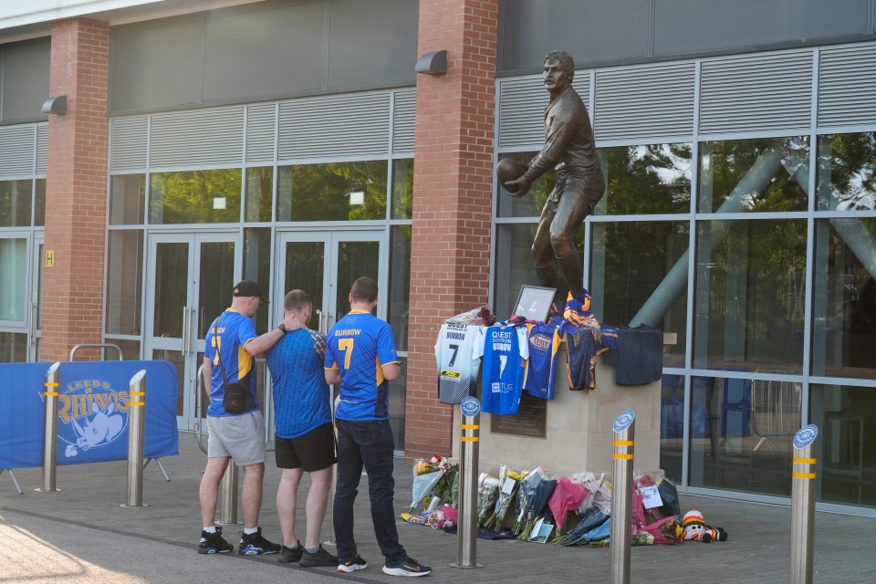 Fans look at flowers and shirts left in honour of Burrow