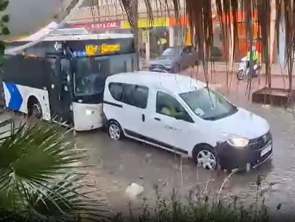 A bus pushed a van through the floodwater