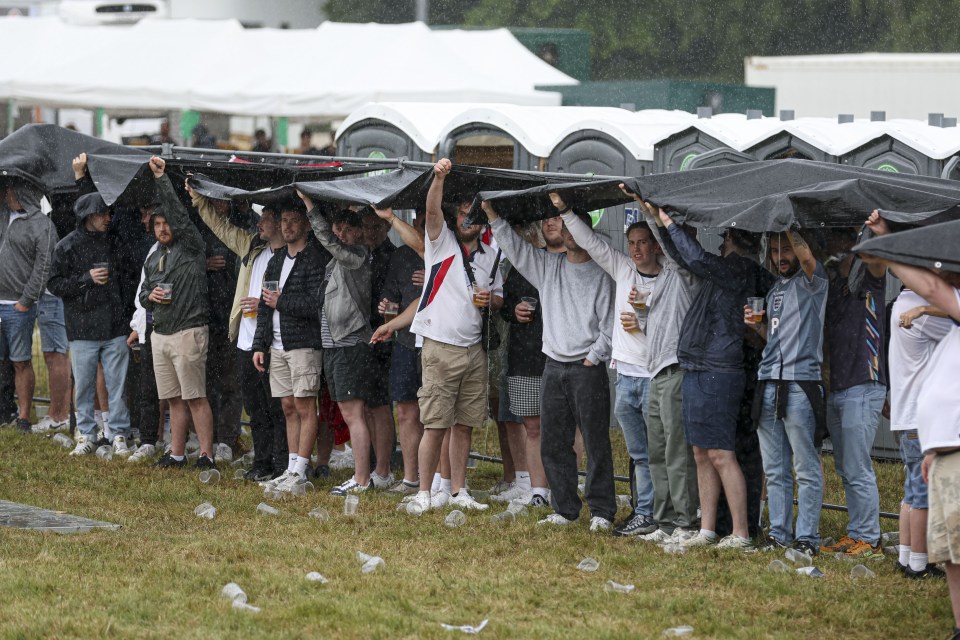 England fans shelter from rain in the fanzone in Gelsenkirchen, during the Serbia v England game