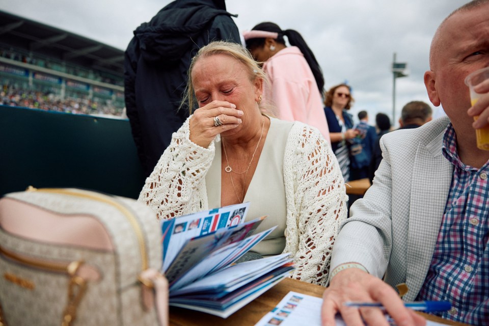 A racegoer cries after horse Tears Of A Clown was fatally injured on the second day of the Epsom Derby Festival