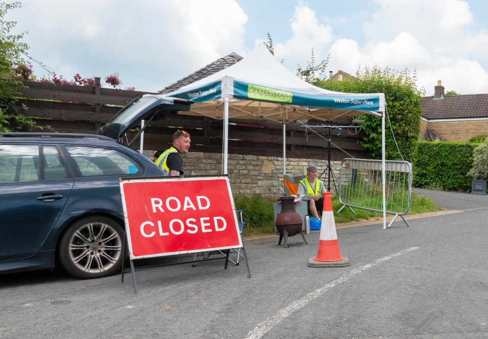 a red sign on the side of the road says road closed