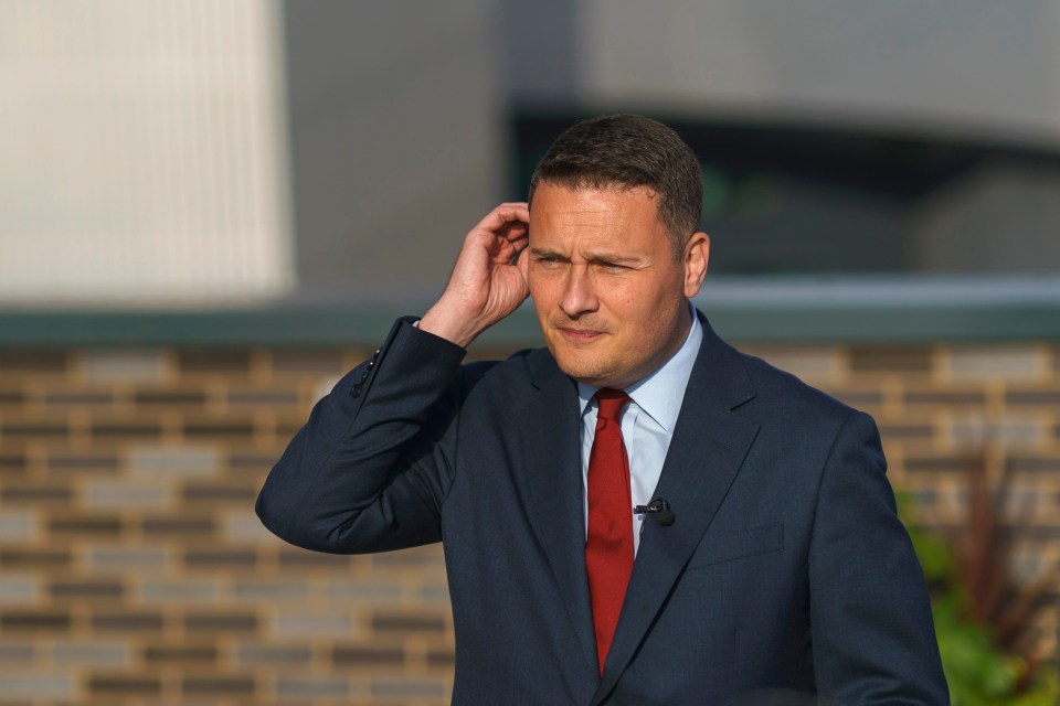 a man in a suit and tie scratches his head