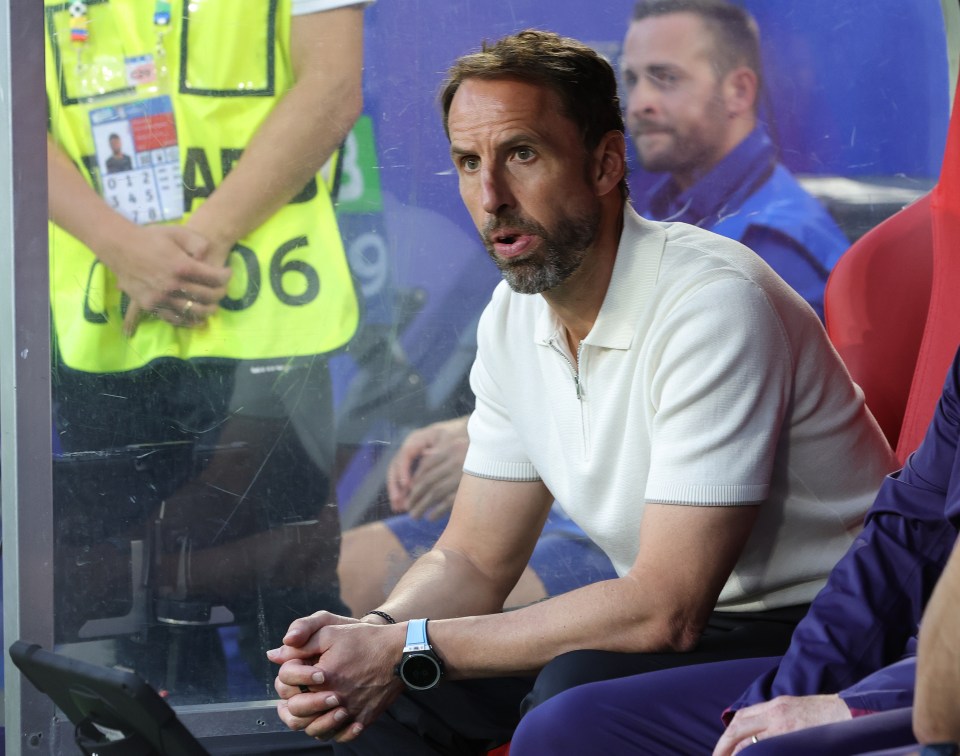 a man wearing a watch sits in a soccer stadium