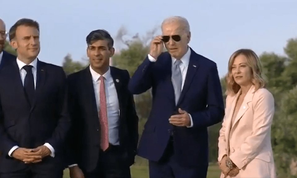 Biden returns for a group picture before slowly putting on his sunglasses