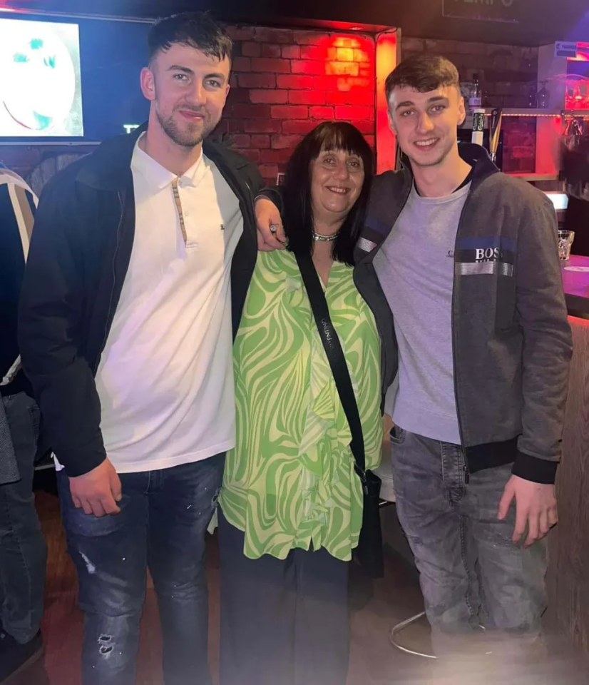 two men and a woman pose for a picture with one wearing a jacket that says boss