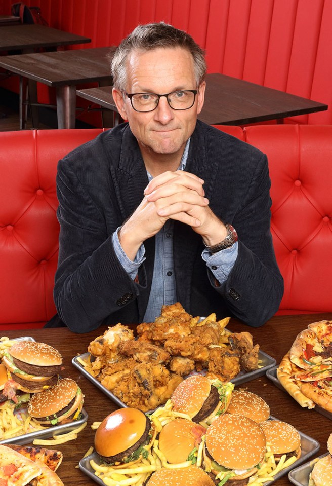 a man sitting in front of a table full of food