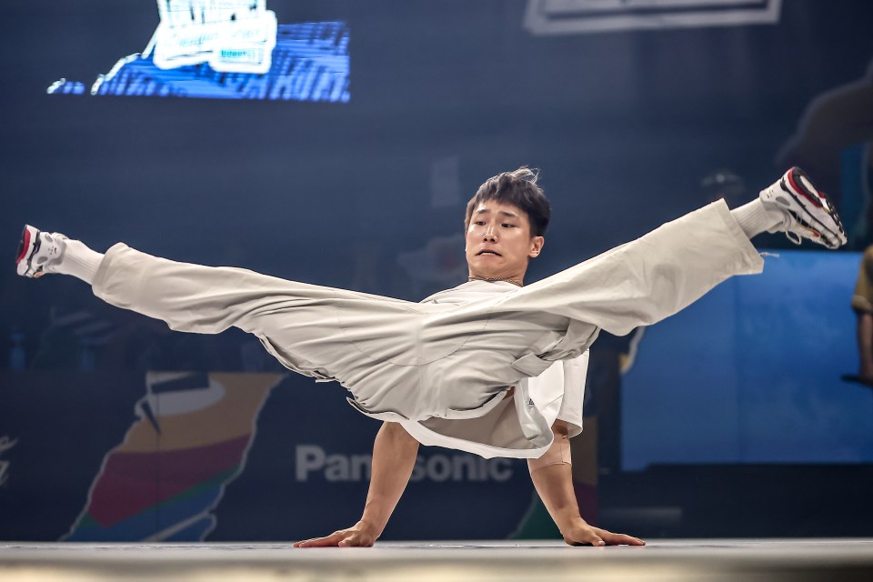 a man is doing a handstand in front of a panasonic sign