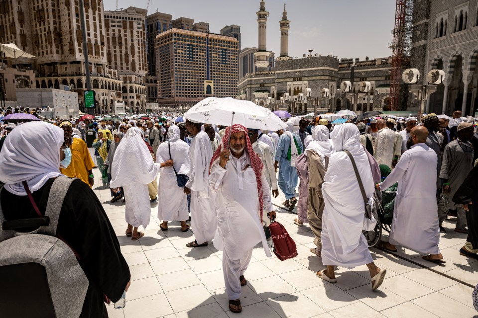 Worshippers hid from the scorching sun under umbrellas