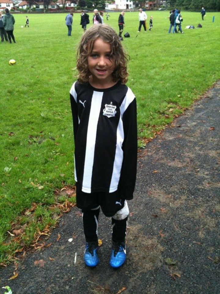 A seven-year-old Jay after a football match with a beaming grin on his face