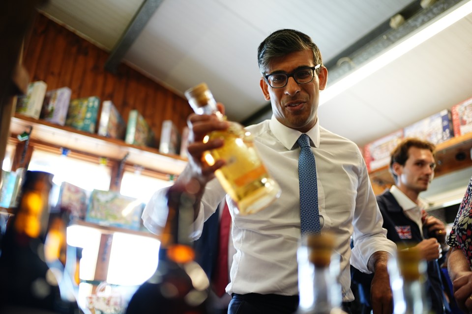 a man in a white shirt and blue tie is holding a bottle