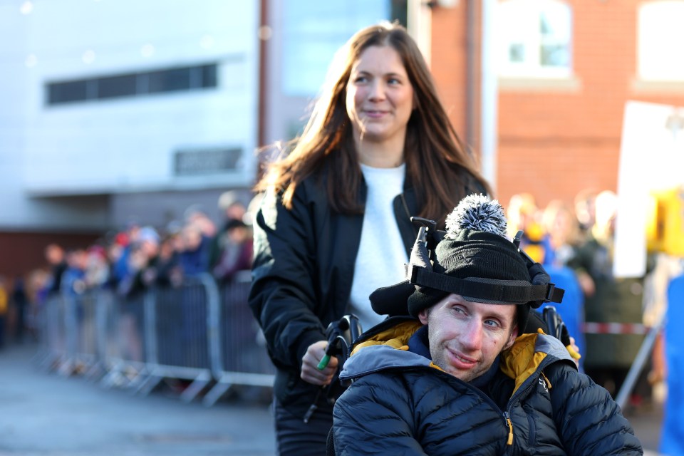 a man in a wheelchair is being pushed by a woman