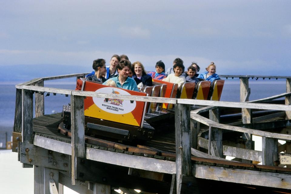 Visitors enjoying the Texas Tornado wooden roller coaster at Frontierland Theme Park in the 1980s