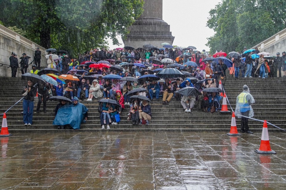 The rain battering down on spectators on the steps opposite the Mall