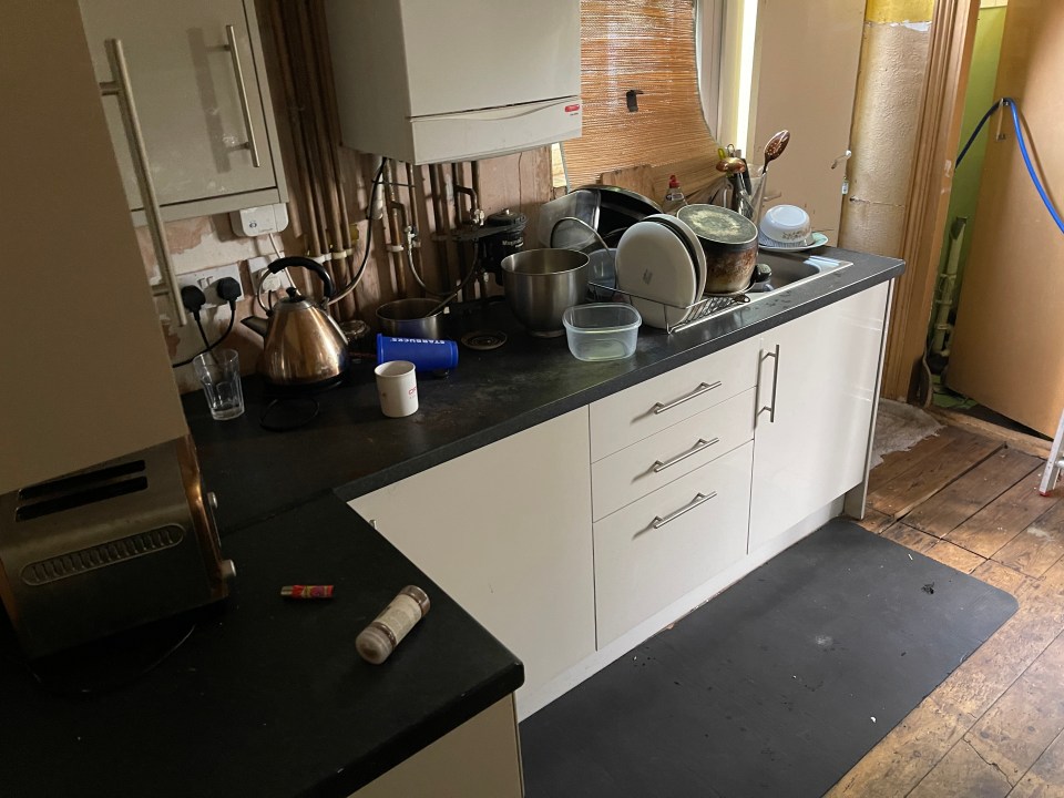 a messy kitchen with a kettle and a toaster