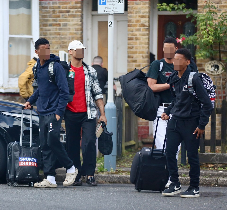 a group of people carrying luggage and a sports direct bag