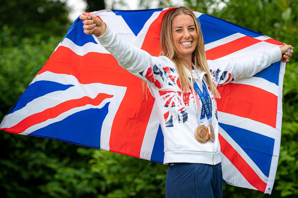 a woman holding a flag and a medal that says tokyo 2020