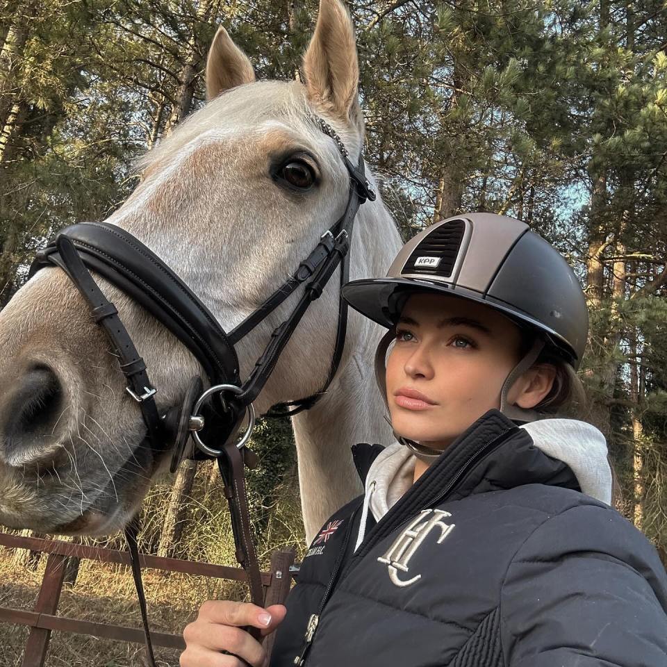 a woman standing next to a horse wearing a helmet that says aep on it