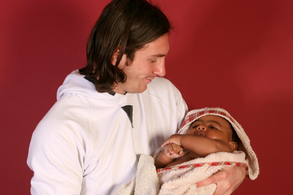 a man is holding a baby wrapped in a towel