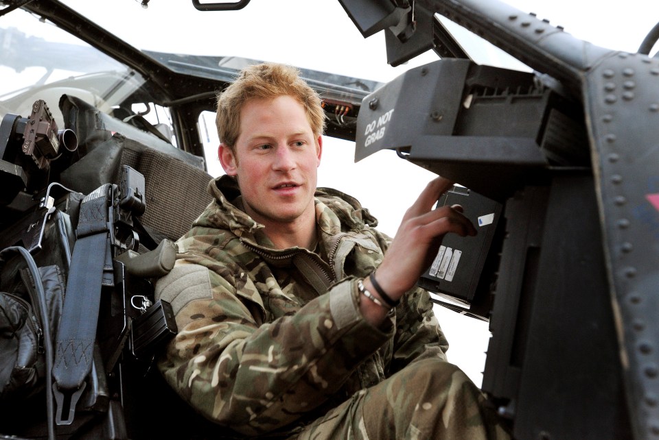 a man in a military uniform sits in the cockpit of a helicopter