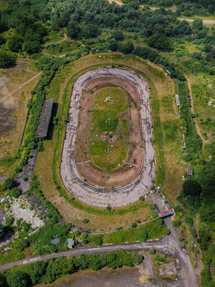 The unused circuit is overgrown with shrubbery and the track is clearly worn away