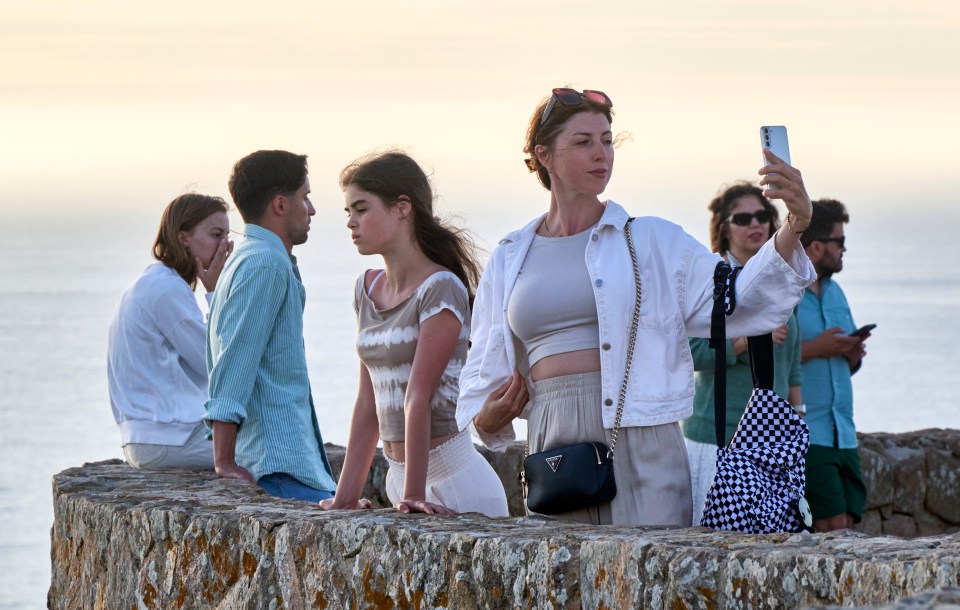 a woman taking a picture of herself with her phone