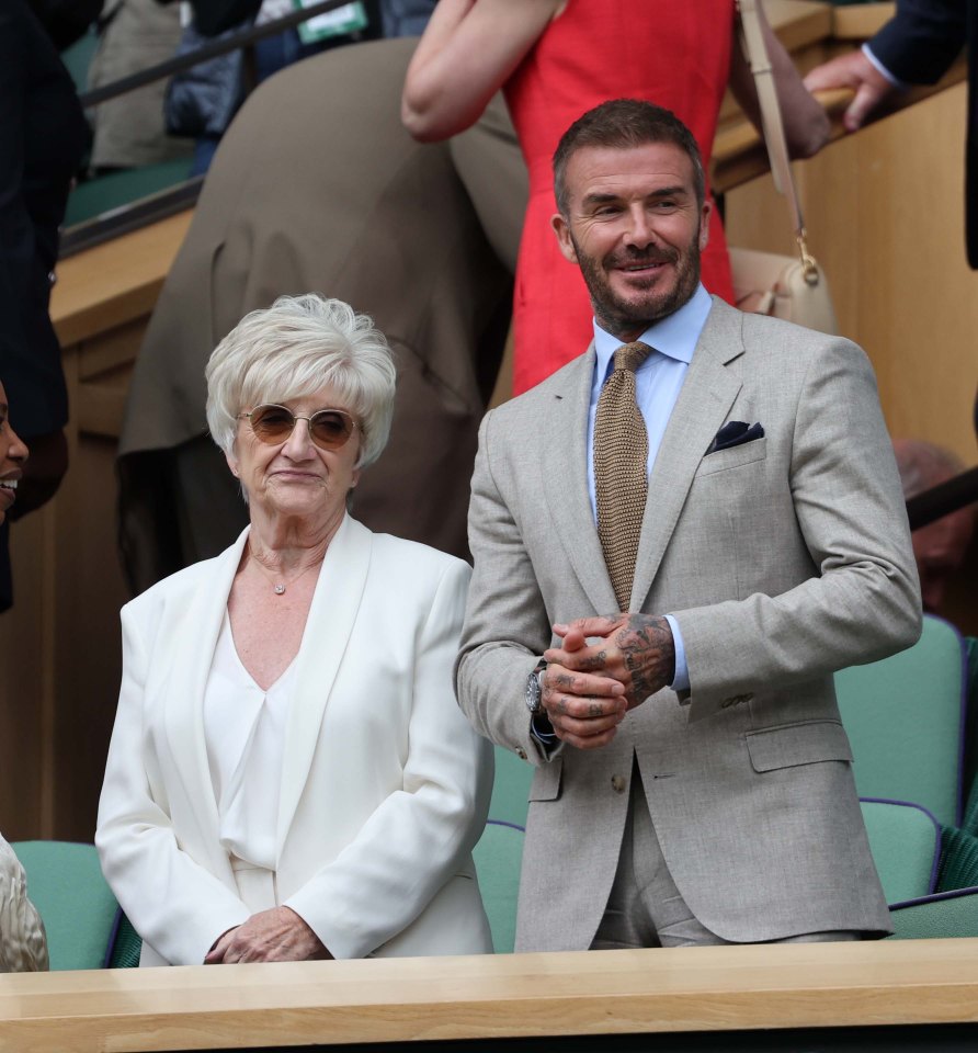 a man in a suit and tie stands next to an older woman