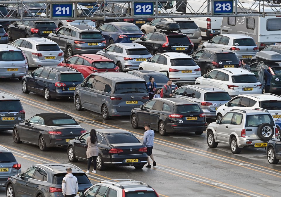 Travellers wait outside their cars at Dover amid huge queues