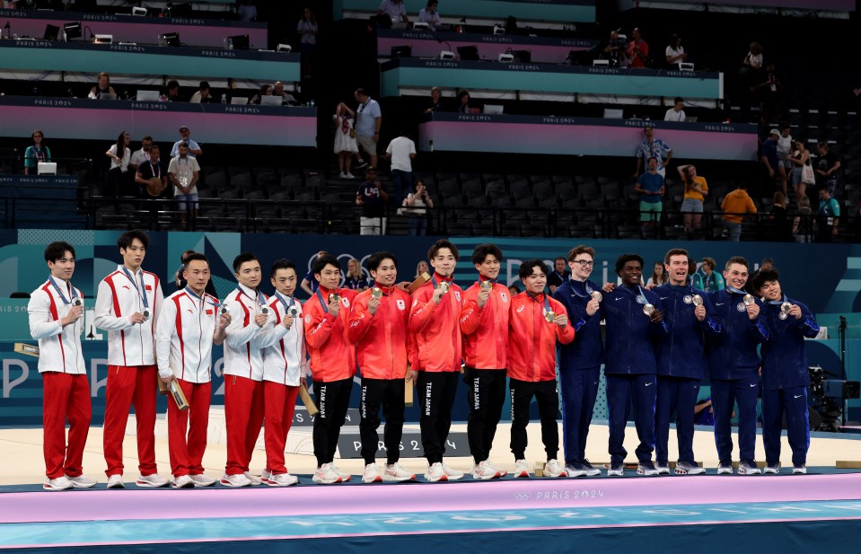 a group of athletes are posing for a photo and one of them has the word japan on his pants