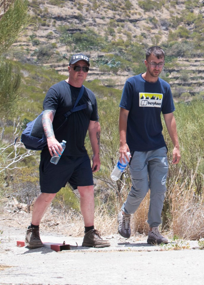 a man wearing a berghaus shirt walks with another man