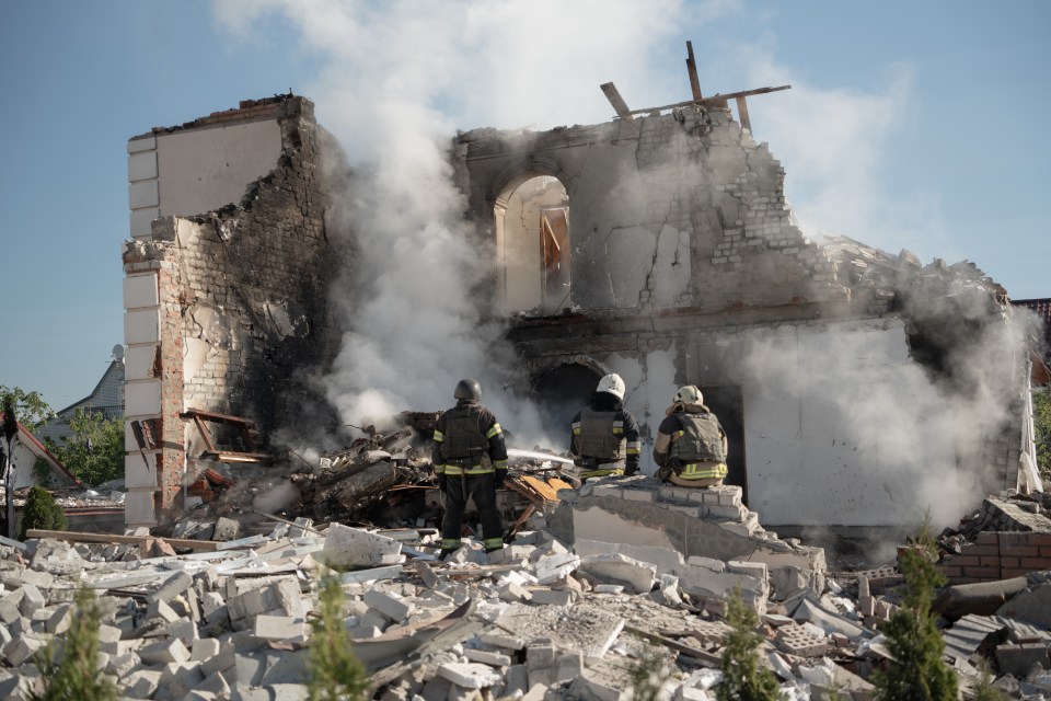 Firefighters finish extinguishing the fire at the site of a Russian missile strike in Kharkiv