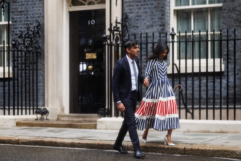 a man and woman are walking down a sidewalk in front of a building with the number 10 on it